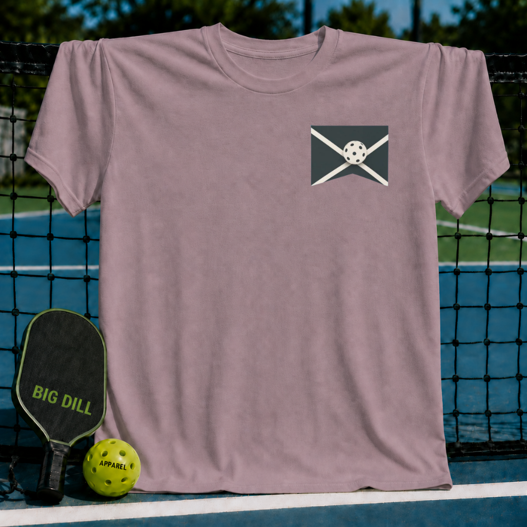 Dusty rose unisex t-shirt featuring a pickleball graphic on a pickleball court with a paddle and ball.