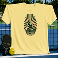 Light yellow crew neck t-shirt featuring a dark green fingerprint graphic with a pickleball paddle design.