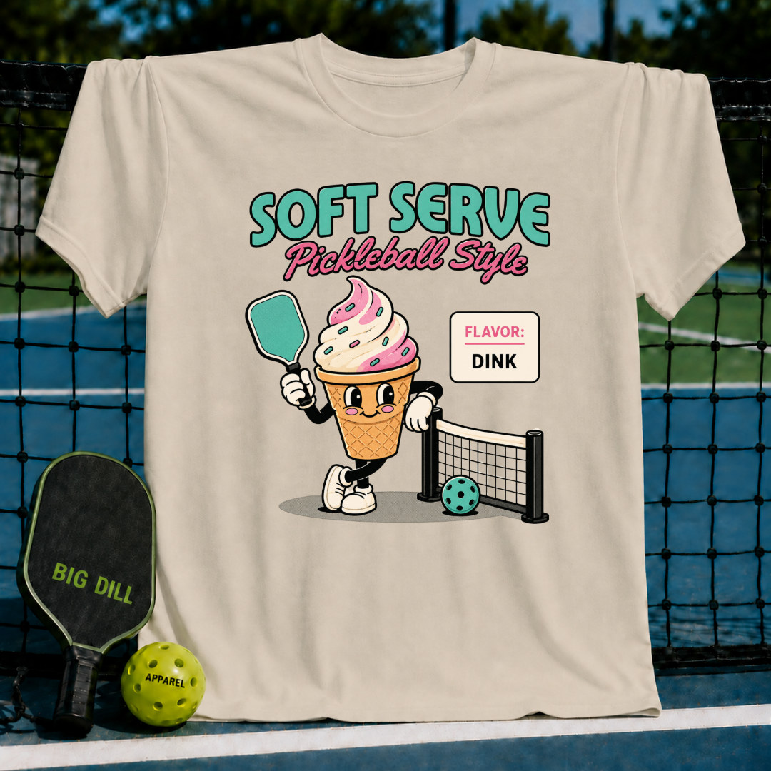 Cream-colored unisex t-shirt featuring a retro ice cream cone character holding a pickleball paddle on a court.