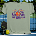 Sage green crewneck t-shirt featuring a mountain, pine tree, and pickleball graphic with the text One More Game I Promise.