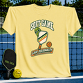 Light yellow crewneck t-shirt featuring a pickleball-themed graphic with a pickle wearing sunglasses and a paddle.
