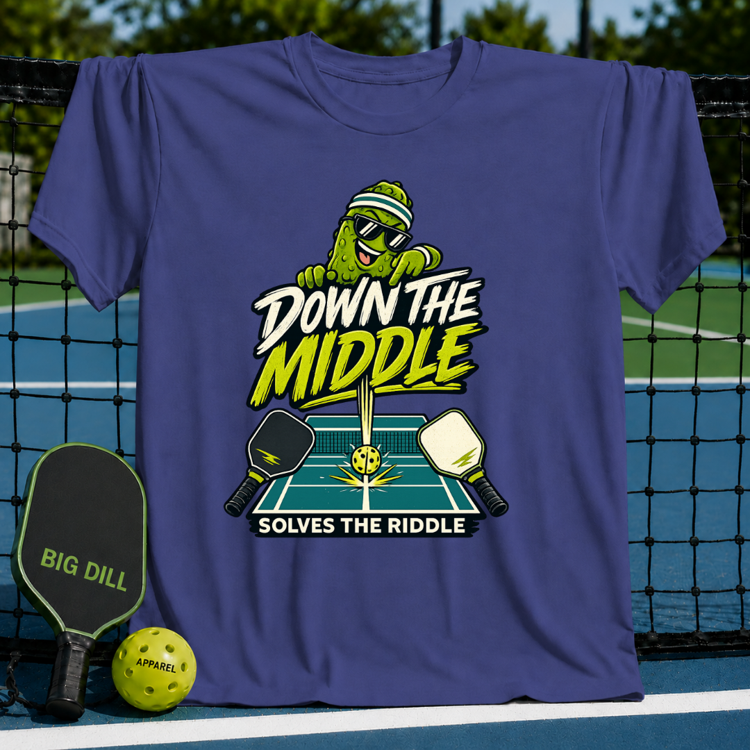 Purple crewneck t-shirt featuring a pickleball-themed graphic with a cartoon pickle, paddles, and court design.