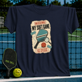 Navy blue crewneck t-shirt featuring a vintage-style pickleball graphic with a paddle, magnifying glass, and funny text.