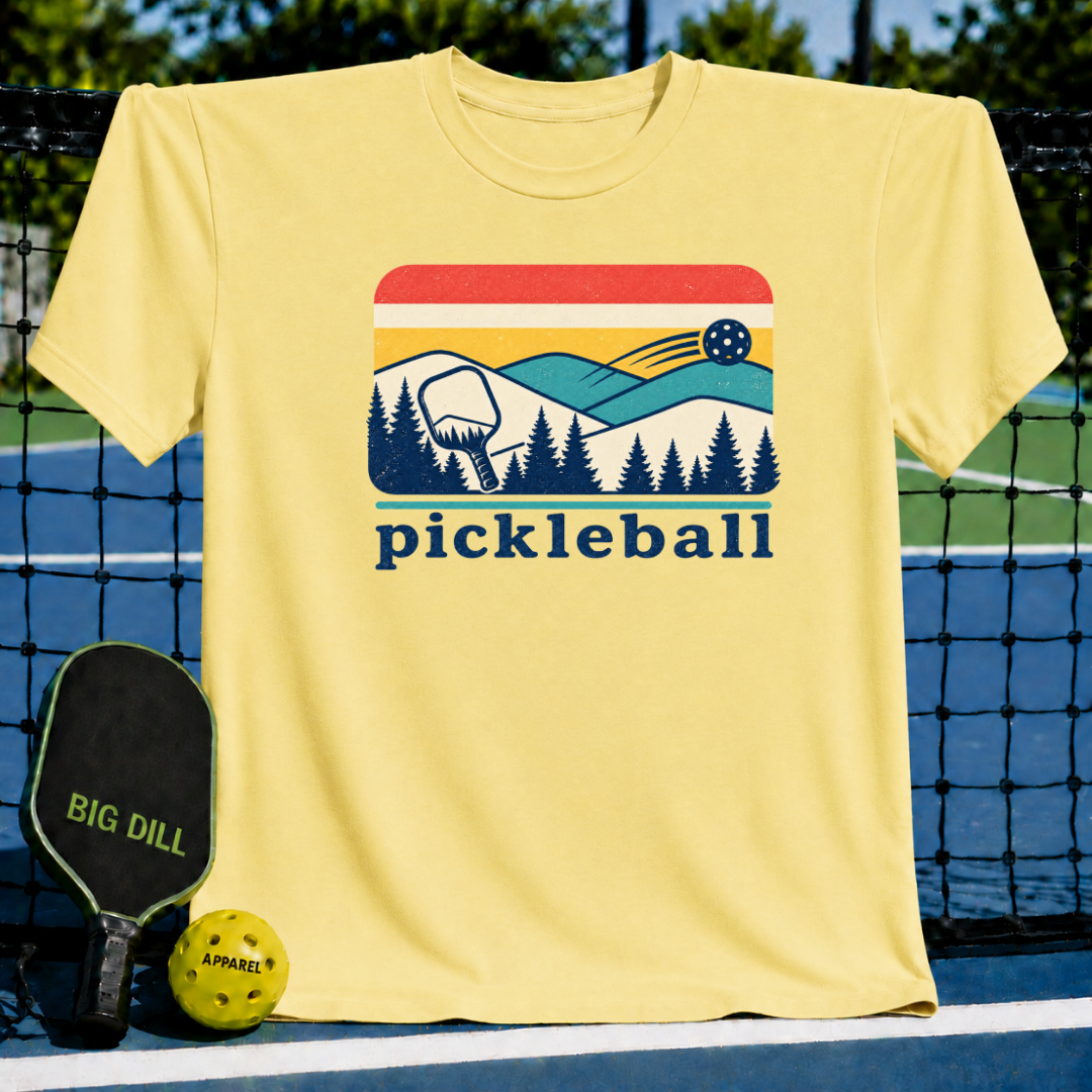 Yellow unisex t-shirt featuring a retro mountain, pine forest, and pickleball graphic with the text pickleball.