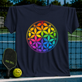 Navy blue t-shirt featuring a colorful, rainbow-gradient Flower of Life design made of pickleball paddles and balls.