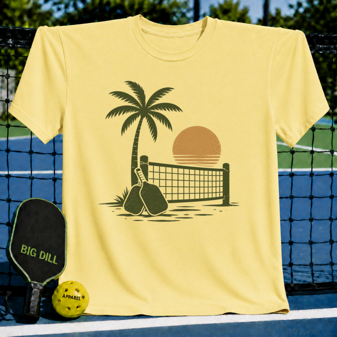Butter yellow unisex t-shirt featuring a brown retro palm tree, pickleball net, and paddle silhouette graphic.