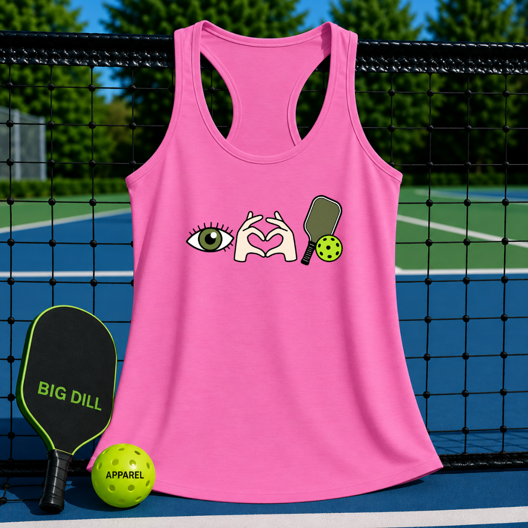Pink racerback tank top featuring an eye, heart-hand gesture, and pickleball paddle graphic on a pickleball court.