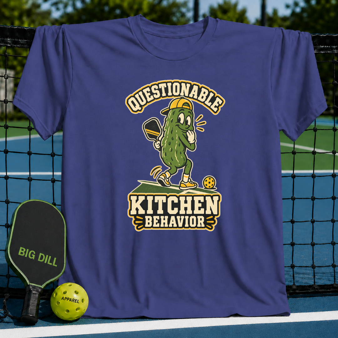 Purple crewneck t-shirt featuring a cartoon pickle playing pickleball with the text Questionable Kitchen Behavior.