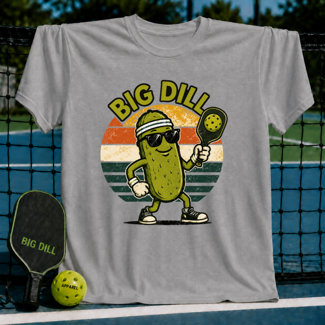 Grey unisex pickleball t-shirt featuring a retro sunset graphic of a cool pickle character with sunglasses and a paddle.
