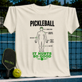 Cream-colored crewneck t-shirt featuring a humorous pickleball injury diagram graphic in black and green ink.