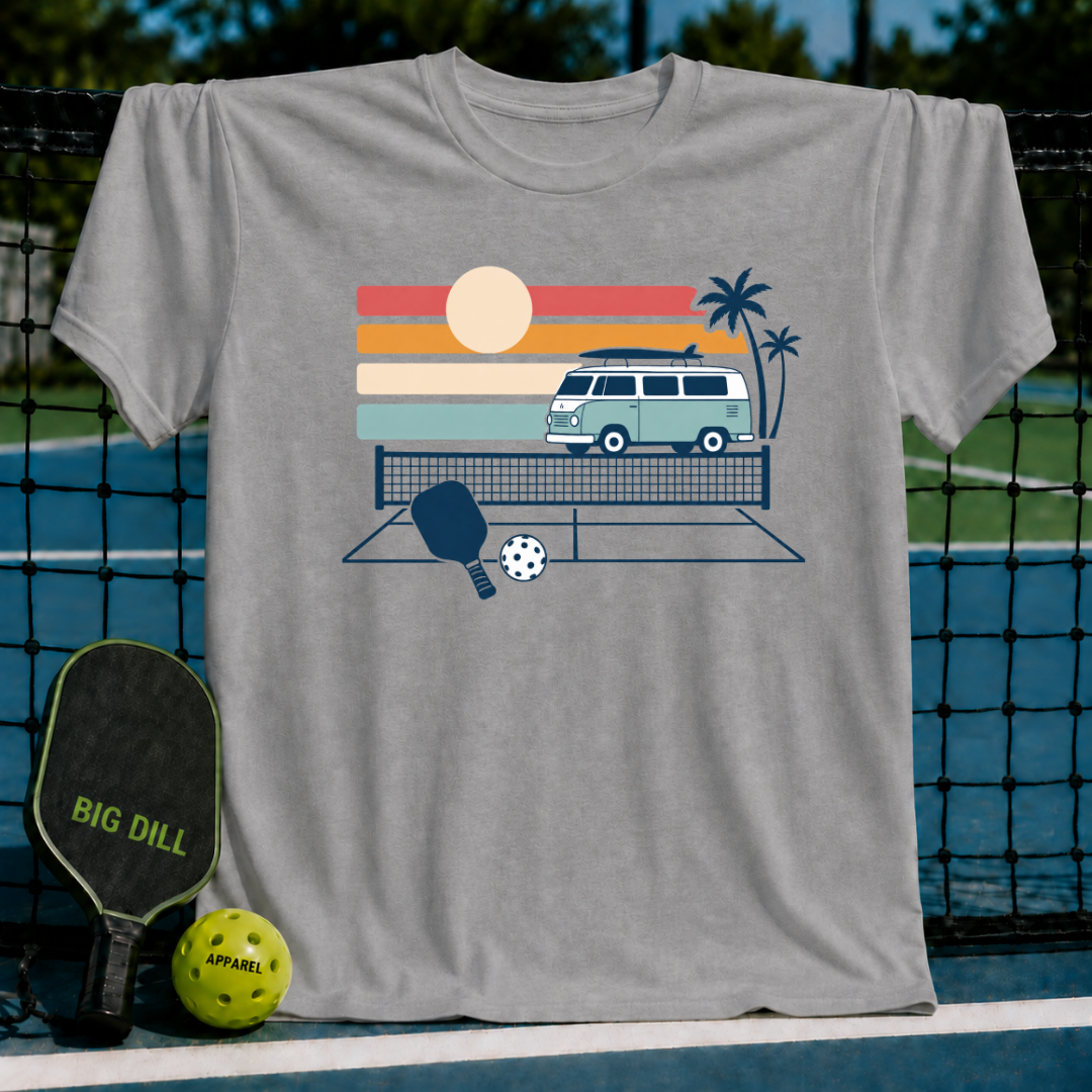 Grey t-shirt featuring a retro van, palm trees, and pickleball gear graphic against a sunset background.