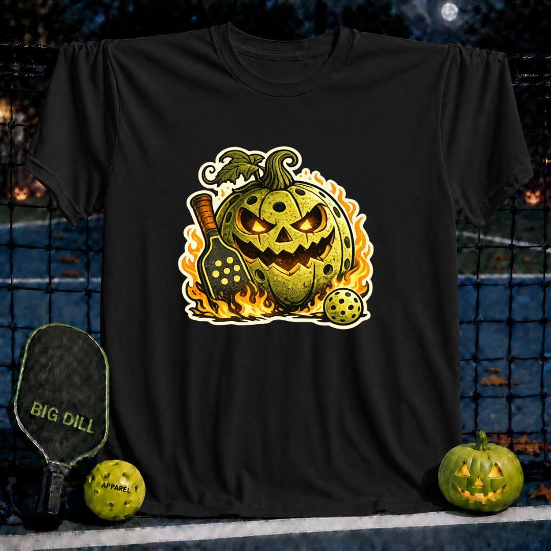 Black unisex t-shirt featuring a flaming jack-o'-lantern pickleball graphic with a paddle and ball on a court background.