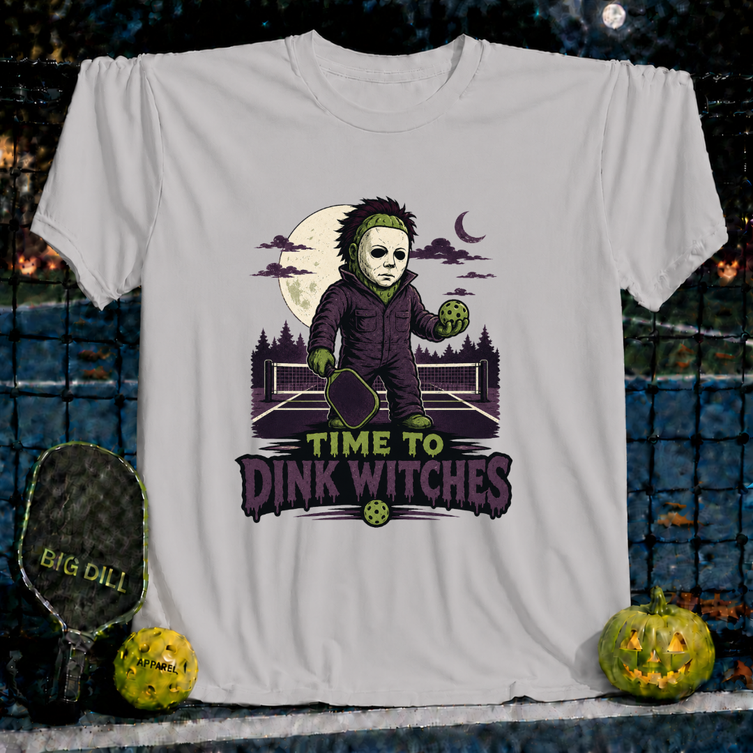 Light grey unisex t-shirt featuring a spooky pickleball-playing character and the text Time to Dink Witches.