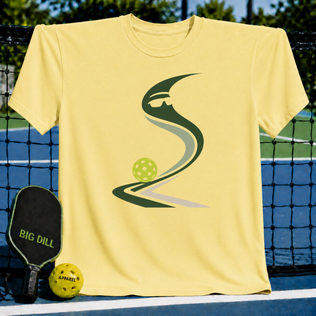 Light yellow crew neck t-shirt featuring a green pickleball-inspired graphic design, displayed on a pickleball court.