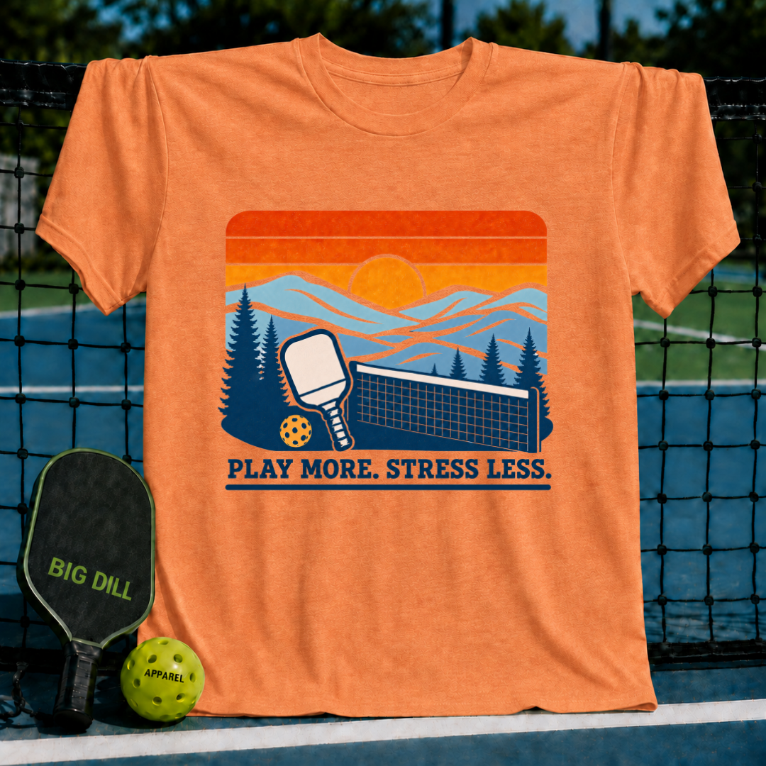 Orange crew neck t-shirt featuring a retro pickleball sunset graphic with the text Play More. Stress Less.