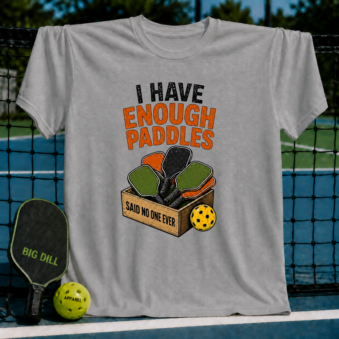 Heather gray unisex t-shirt featuring a retro graphic of a wooden crate filled with colorful pickleball paddles.
