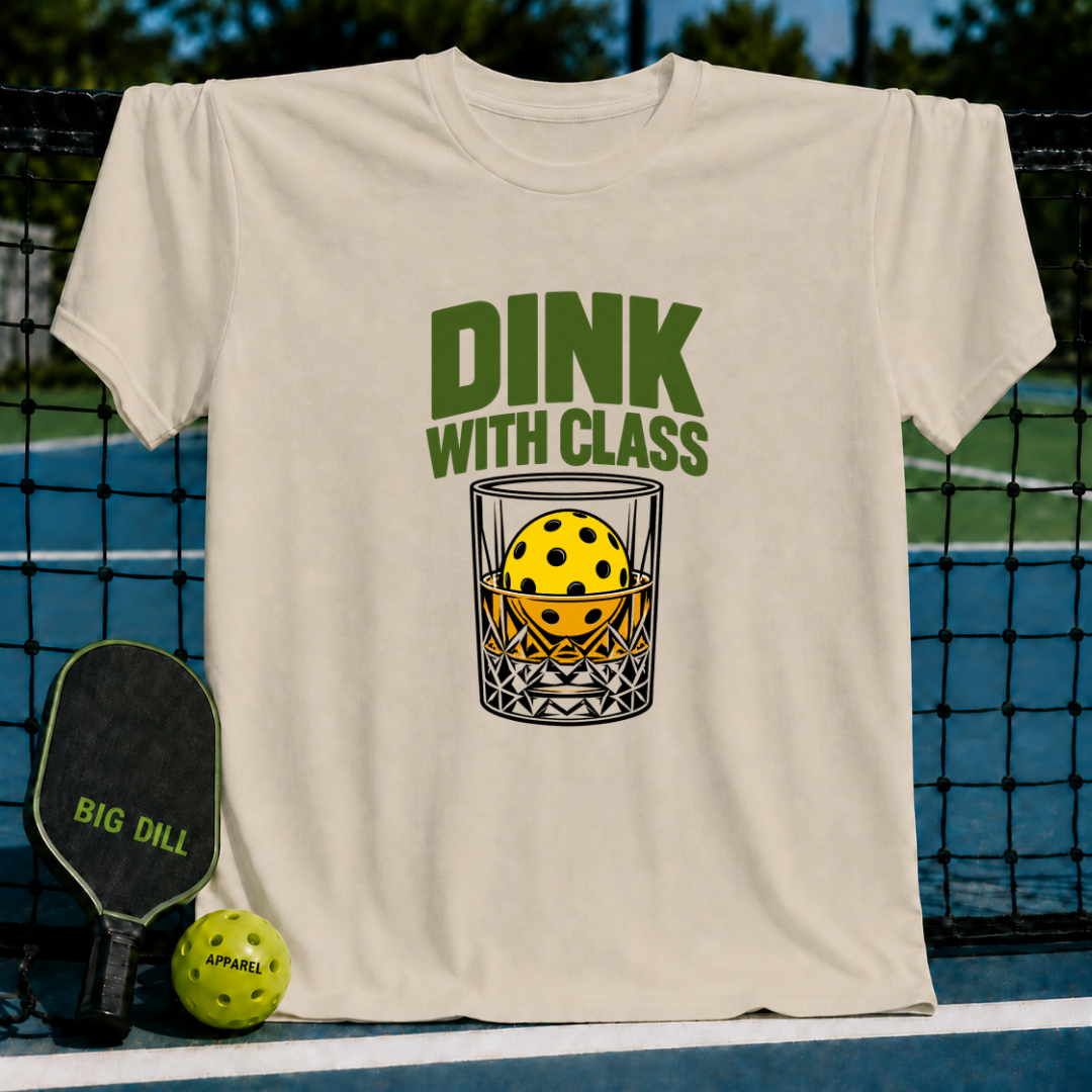 Beige crewneck t-shirt featuring a green Dink With Class graphic of a pickleball in a whiskey glass on a court background.