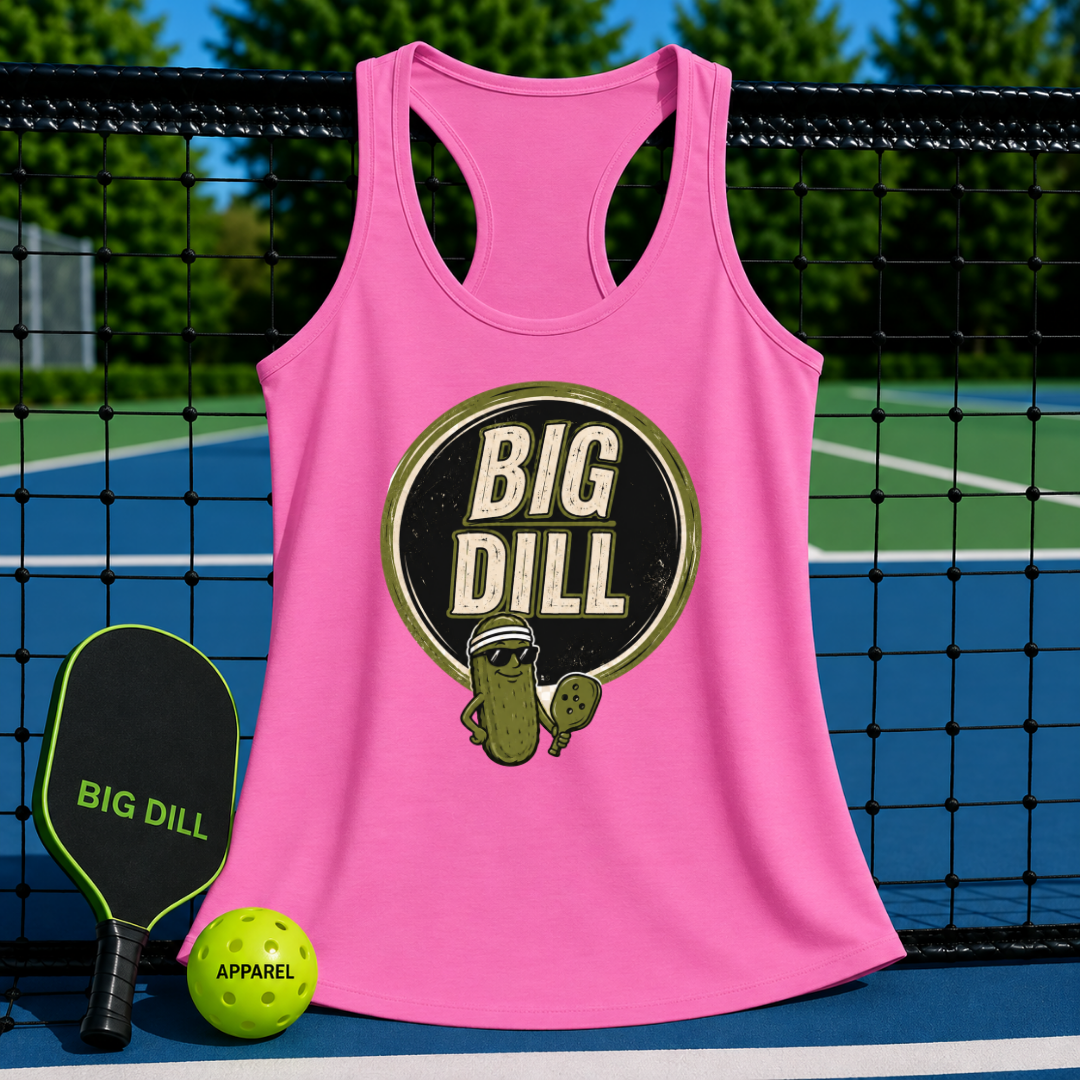 Pink racerback tank top with a retro Big Dill pickle graphic, displayed on a pickleball court with a paddle and ball.