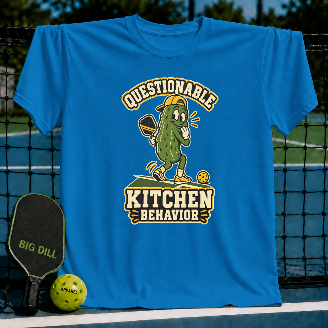 Bright blue crewneck t-shirt featuring a cartoon pickle playing pickleball with the text Questionable Kitchen Behavior.
