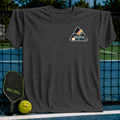 Charcoal grey unisex t-shirt featuring a mountain and pickleball court crest graphic on a pickleball court background.