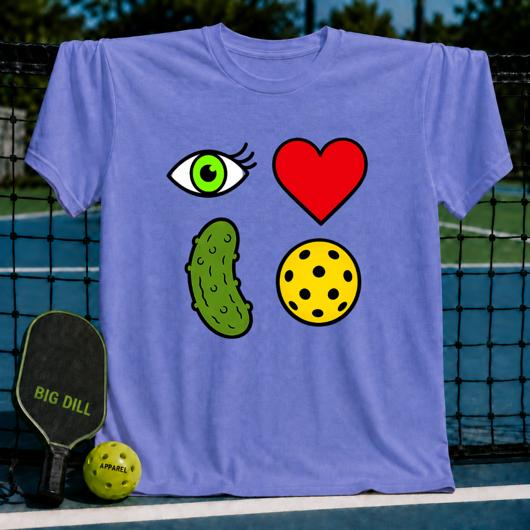 Light blue unisex t-shirt featuring a 2x2 rebus graphic of an eye, heart, pickle, and ball on a pickleball court.