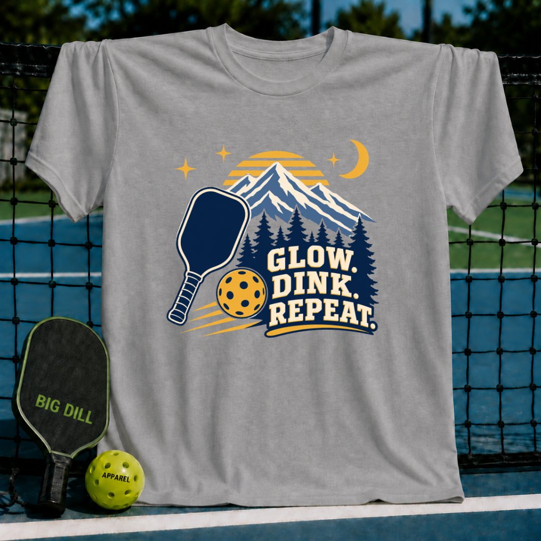 Grey crewneck t-shirt featuring a mountain, pickleball paddle, and ball graphic with Glow Dink Repeat text.