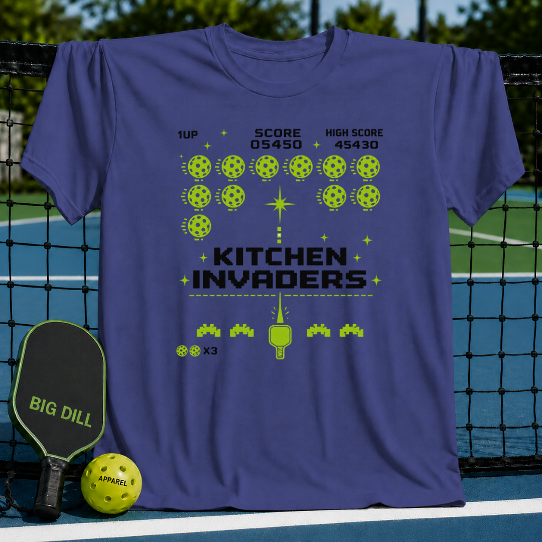Blue unisex t-shirt featuring a green pixel-art arcade game design with pickleballs and a paddle on a pickleball court.