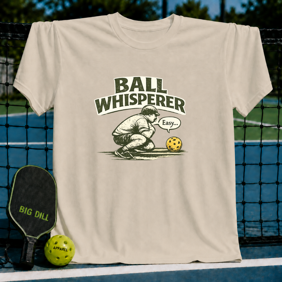 Cream unisex t-shirt featuring a vintage illustration of a pickleball player whispering to a ball with collegiate text.