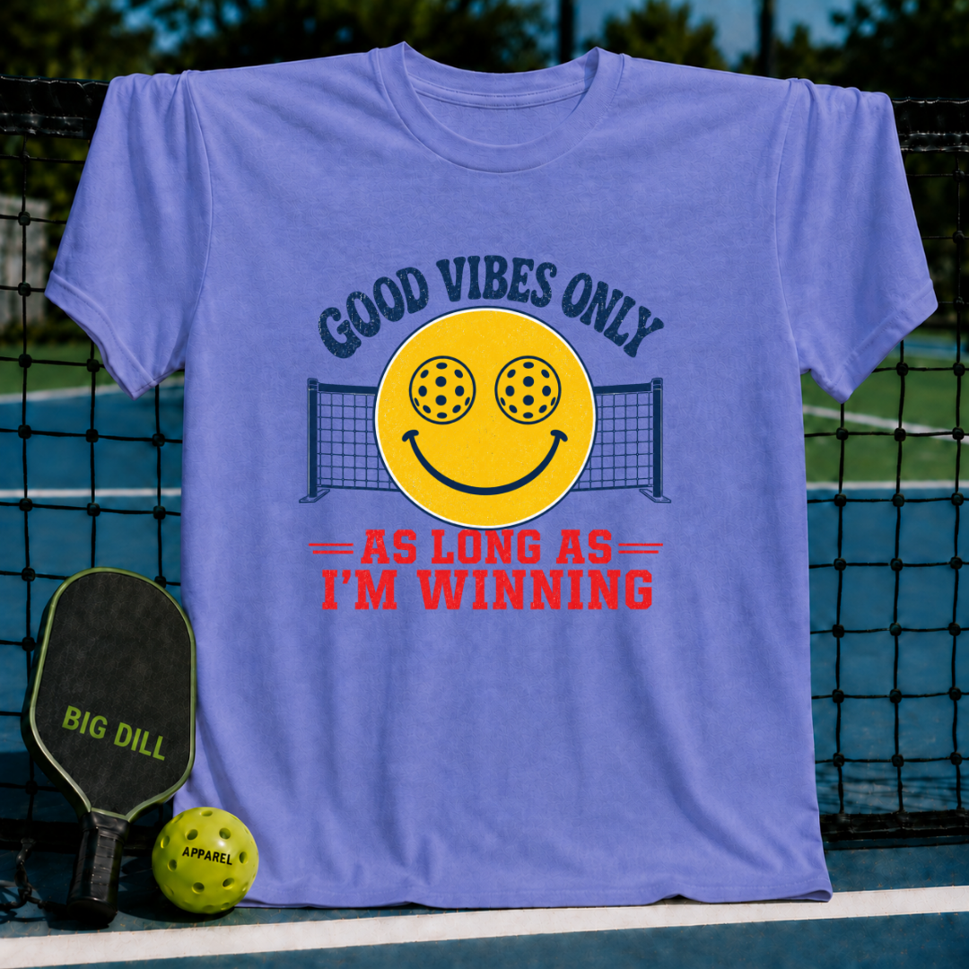 Periwinkle unisex t-shirt featuring a yellow smiley face with pickleball eyes and a net graphic, with bold text on a court.