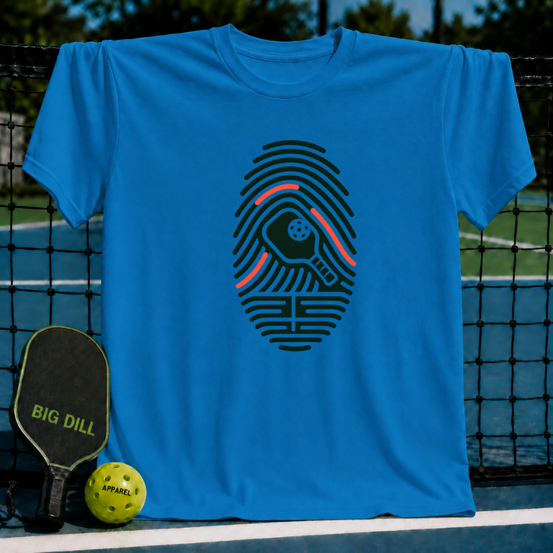 Bright blue crew neck t-shirt featuring a dark green fingerprint graphic with a pickleball paddle and ball design.
