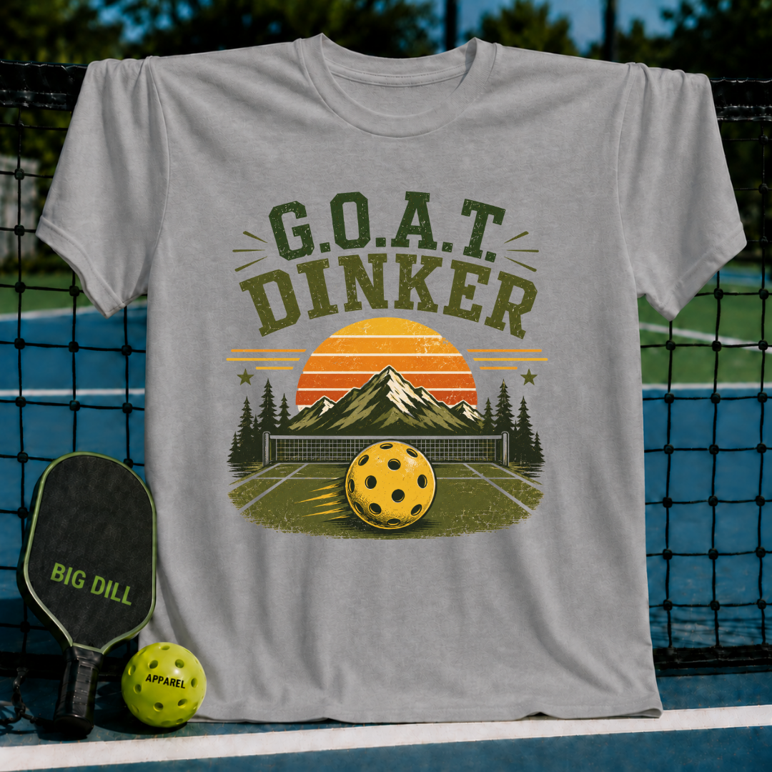 Grey unisex t-shirt featuring a retro mountain sunset graphic with a pickleball and the text G.O.A.T. DINKER.