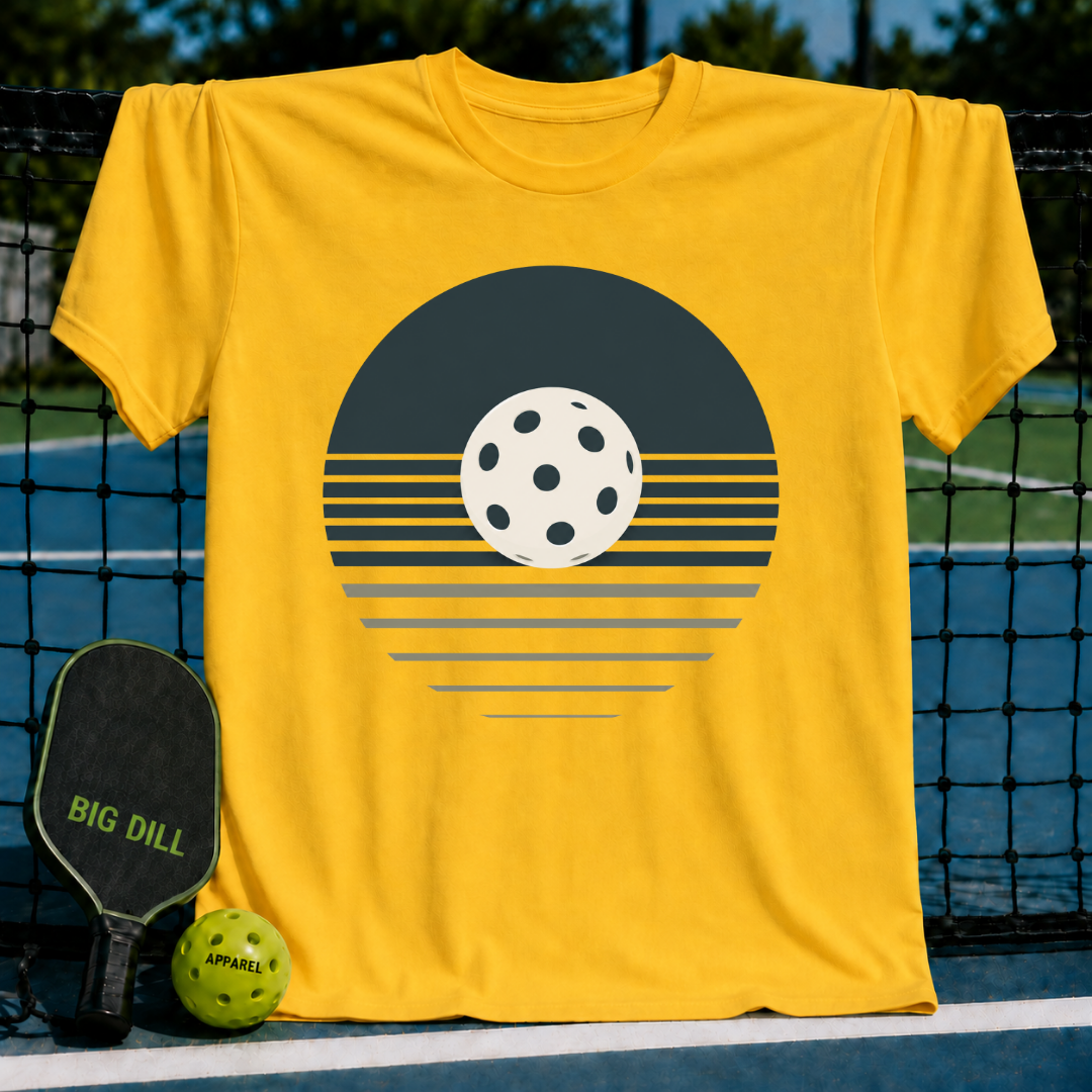 Bright yellow unisex t-shirt featuring a minimalist retro pickleball sunset graphic on a pickleball court background.