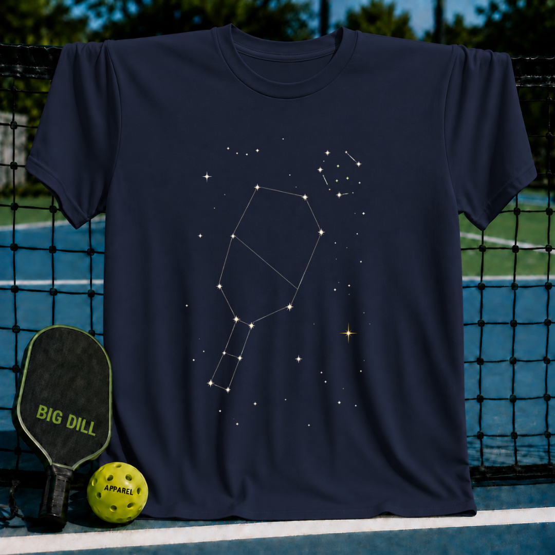 Navy blue crewneck t-shirt featuring a white pickleball paddle constellation graphic on a pickleball court background.
