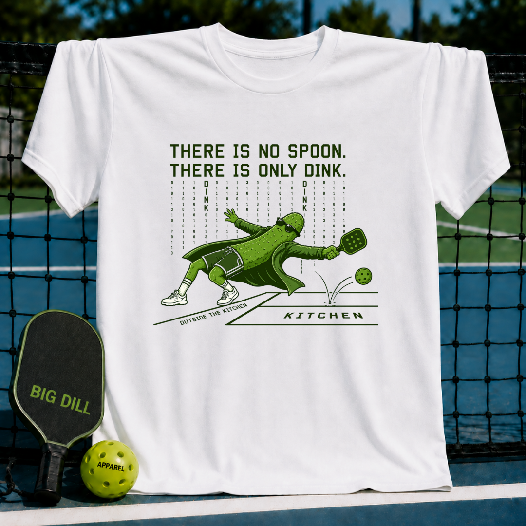 White unisex t-shirt featuring a caped pickle character diving for a pickleball with binary code and text graphic.
