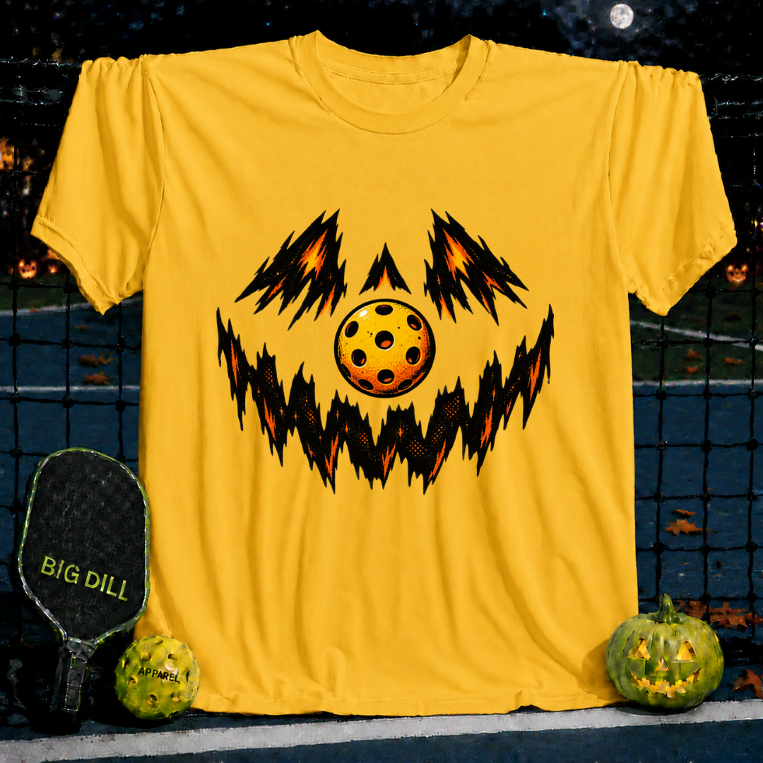 Yellow crew neck t-shirt featuring a spooky jack-o'-lantern face design made with a pickleball graphic.