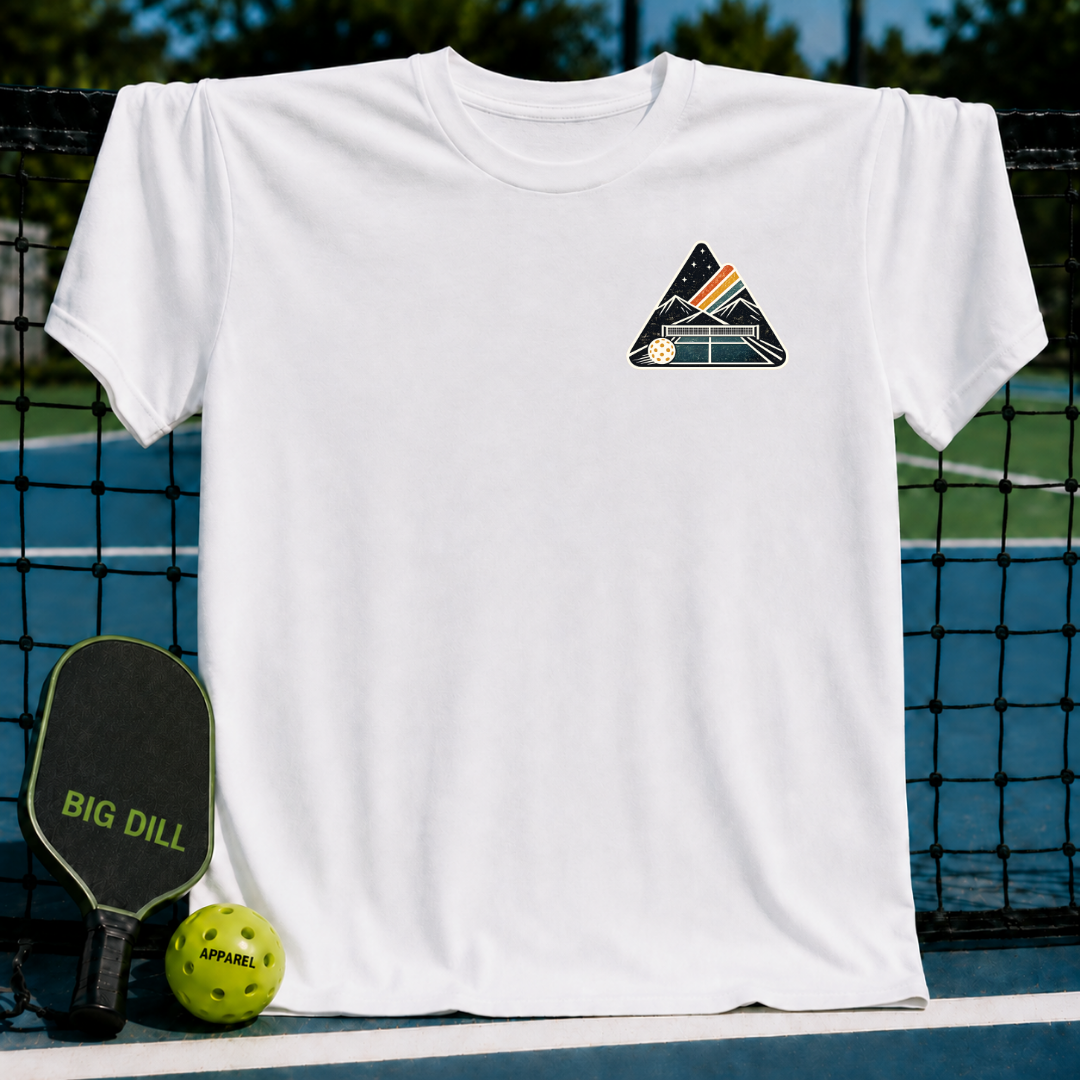 White unisex t-shirt featuring a mountain and pickleball crest graphic on a court background.