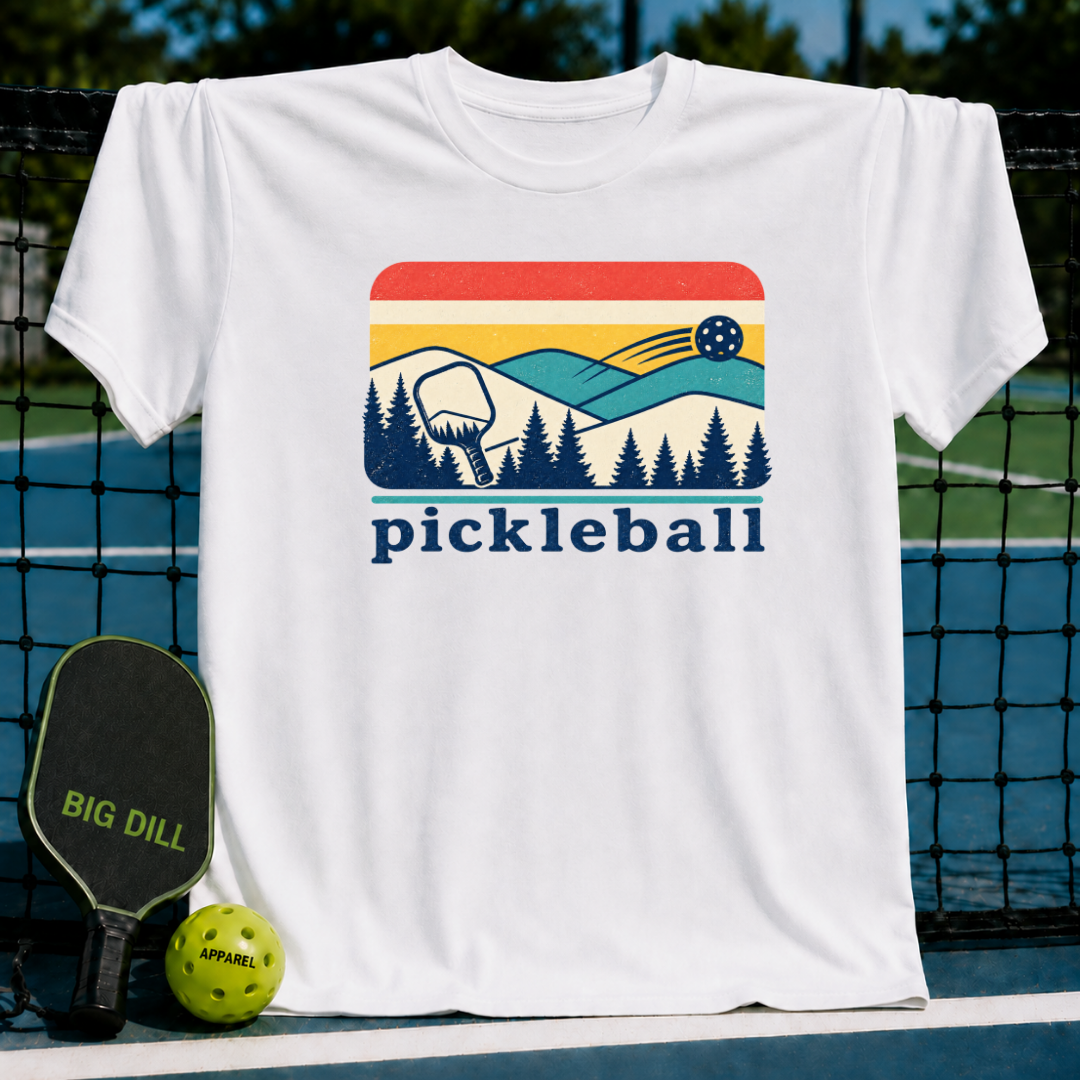 White unisex t-shirt featuring a retro mountain, pine forest, and pickleball graphic with the word pickleball below.