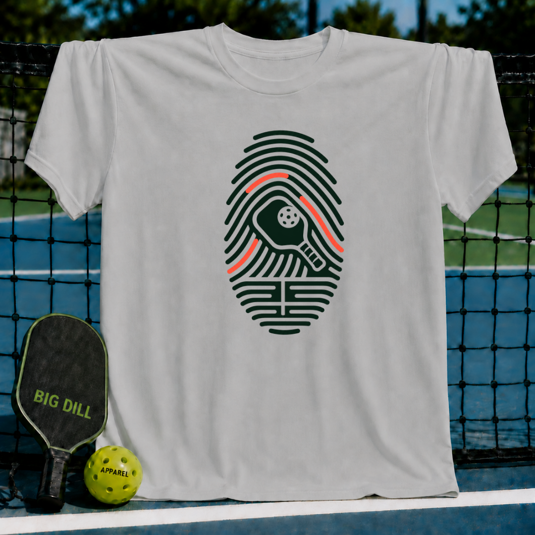 Light gray crew neck t-shirt featuring a dark green fingerprint graphic with a pickleball paddle and ball design.