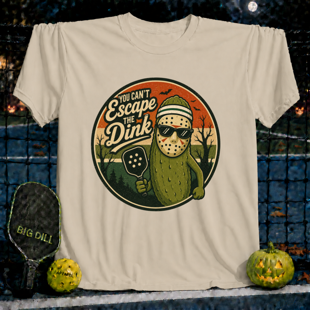 Sand-colored unisex t-shirt featuring a pickleball-themed Jason Voorhees pickle graphic with sunglasses and a paddle.