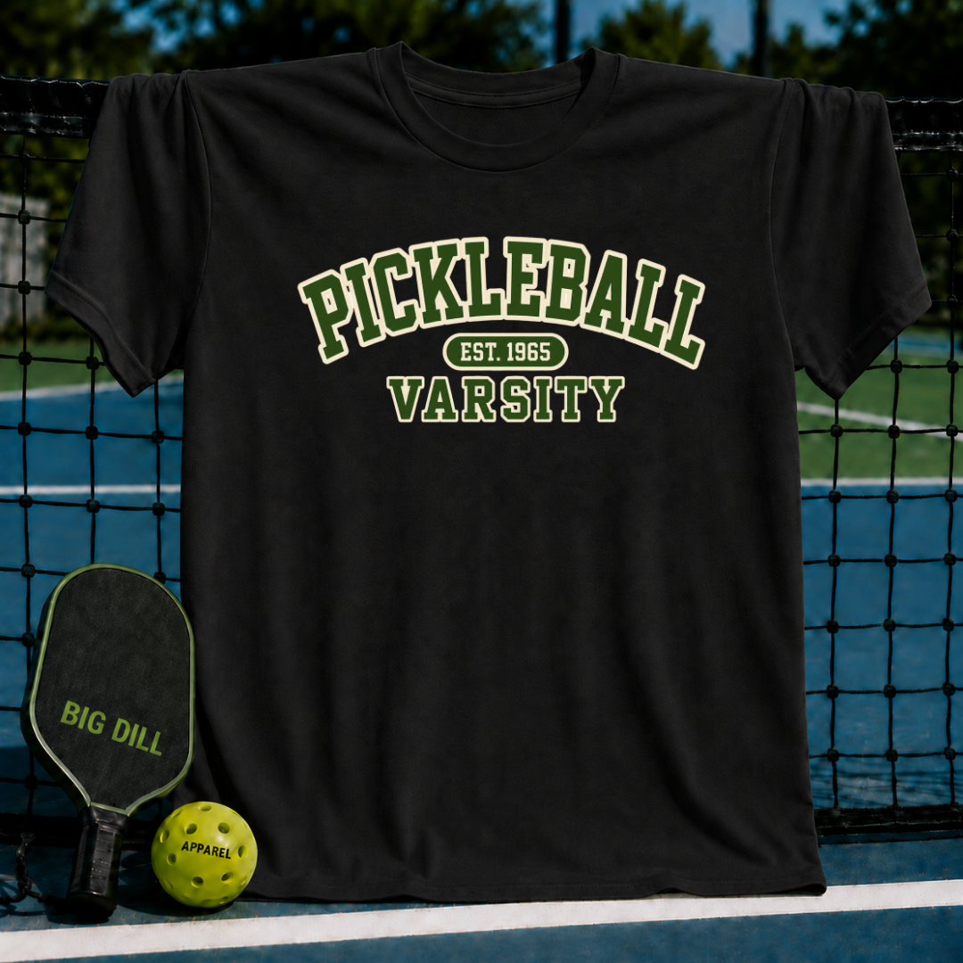 Black cotton crewneck t-shirt featuring a green and white vintage-style Pickleball Varsity graphic on a pickleball court.