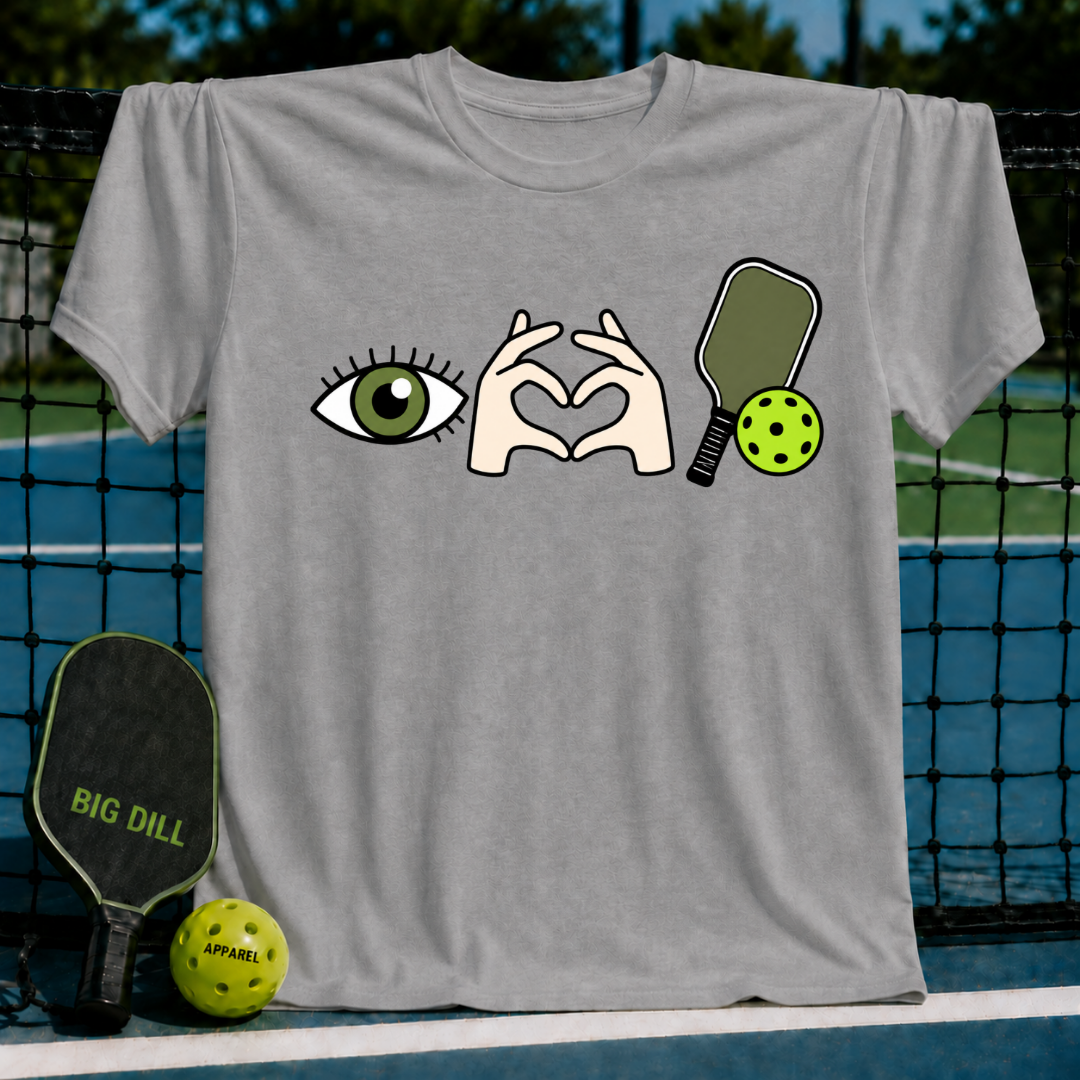 Grey cotton t-shirt featuring an eye, heart-shaped hands, and a pickleball paddle graphic on a court background.