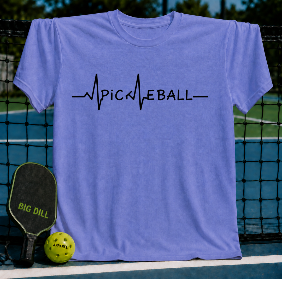 Periwinkle blue unisex t-shirt featuring a black EKG heartbeat line graphic that spells out Pickleball on a court.