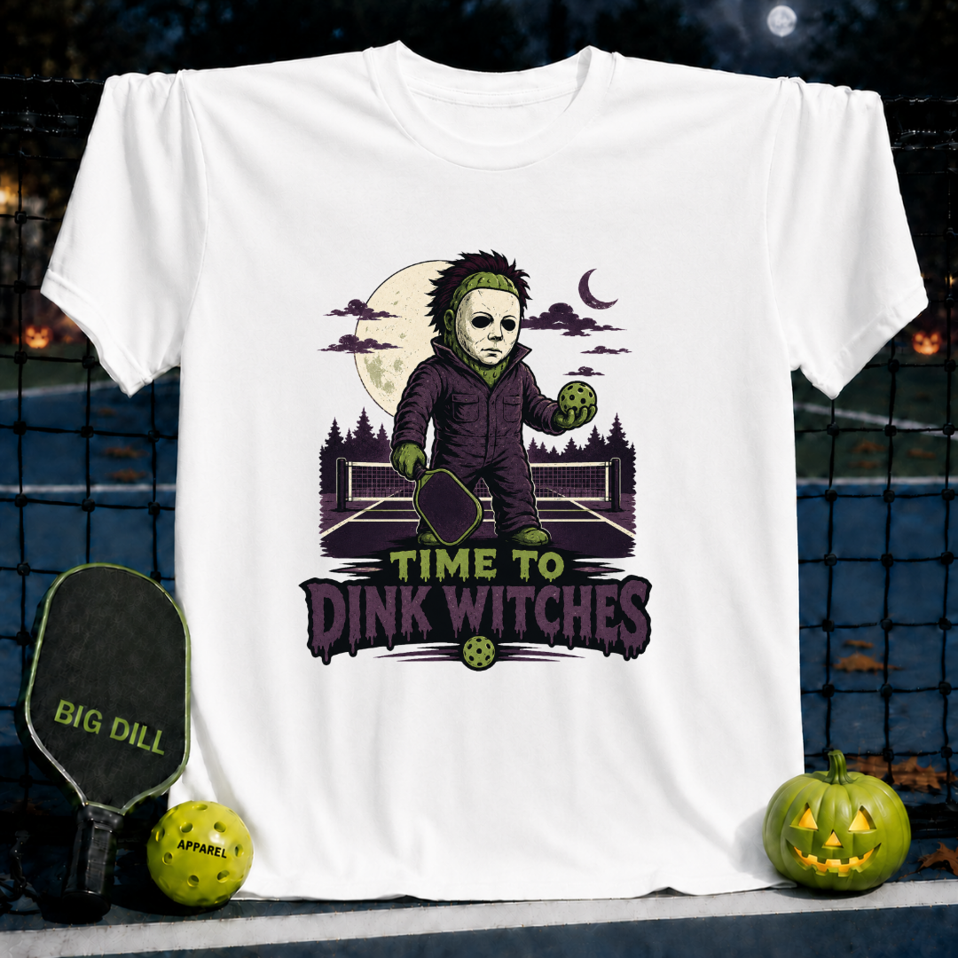 White unisex t-shirt featuring a spooky pickleball-playing character and the text Time to Dink Witches on a pickleball court.