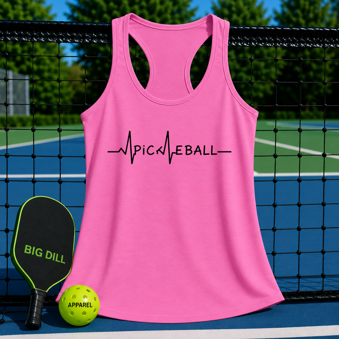 Pink racerback tank top with black Pickleball EKG heartbeat graphic, displayed on a pickleball court with paddle and ball.