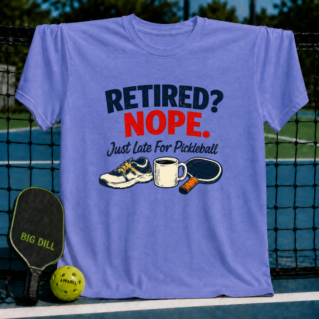 Light blue crew neck t-shirt featuring a Retired? Nope. Just Late For Pickleball graphic with a sneaker, mug, and paddle.
