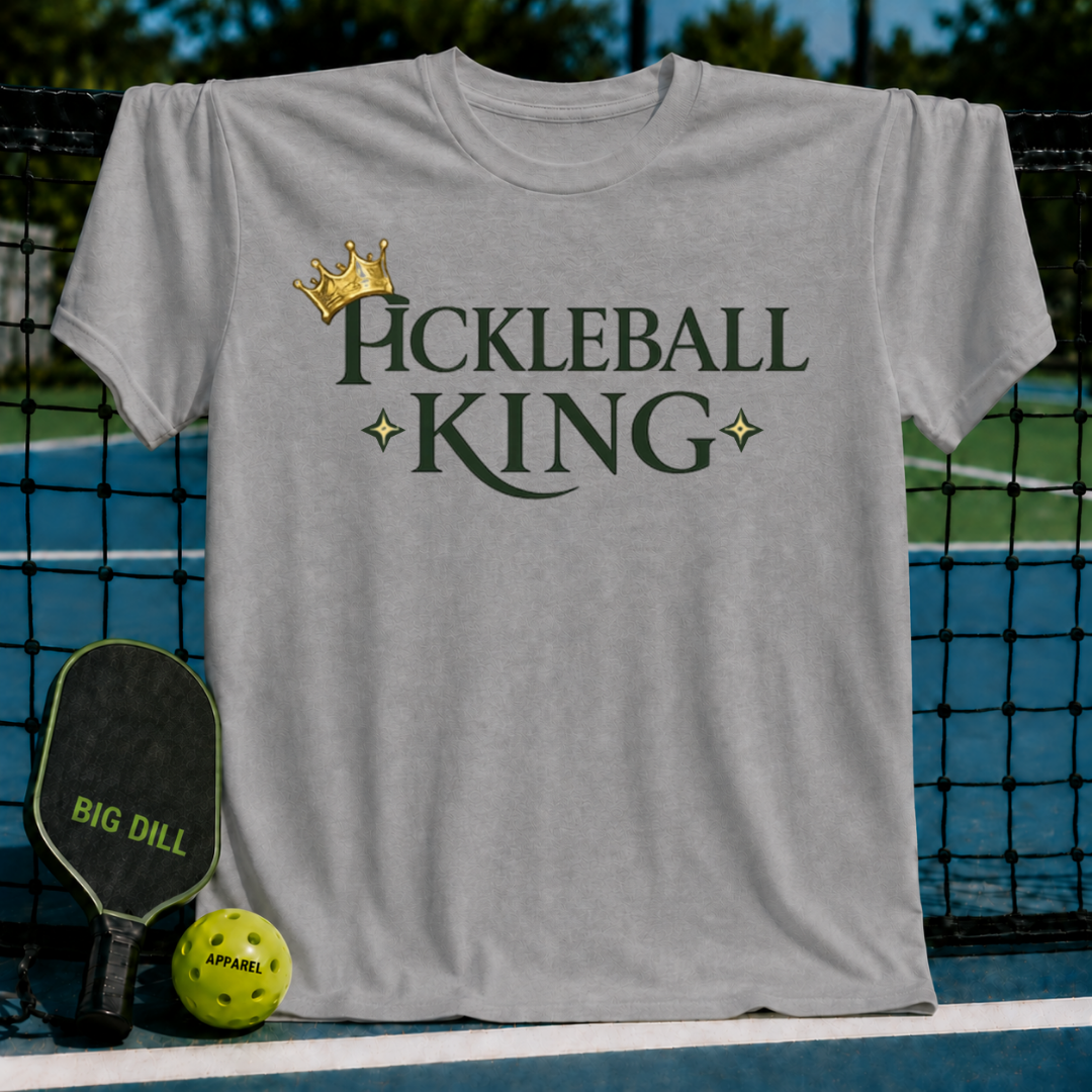 Light gray unisex t-shirt featuring dark green Pickleball King text, a gold crown, and star accents on a pickleball court.