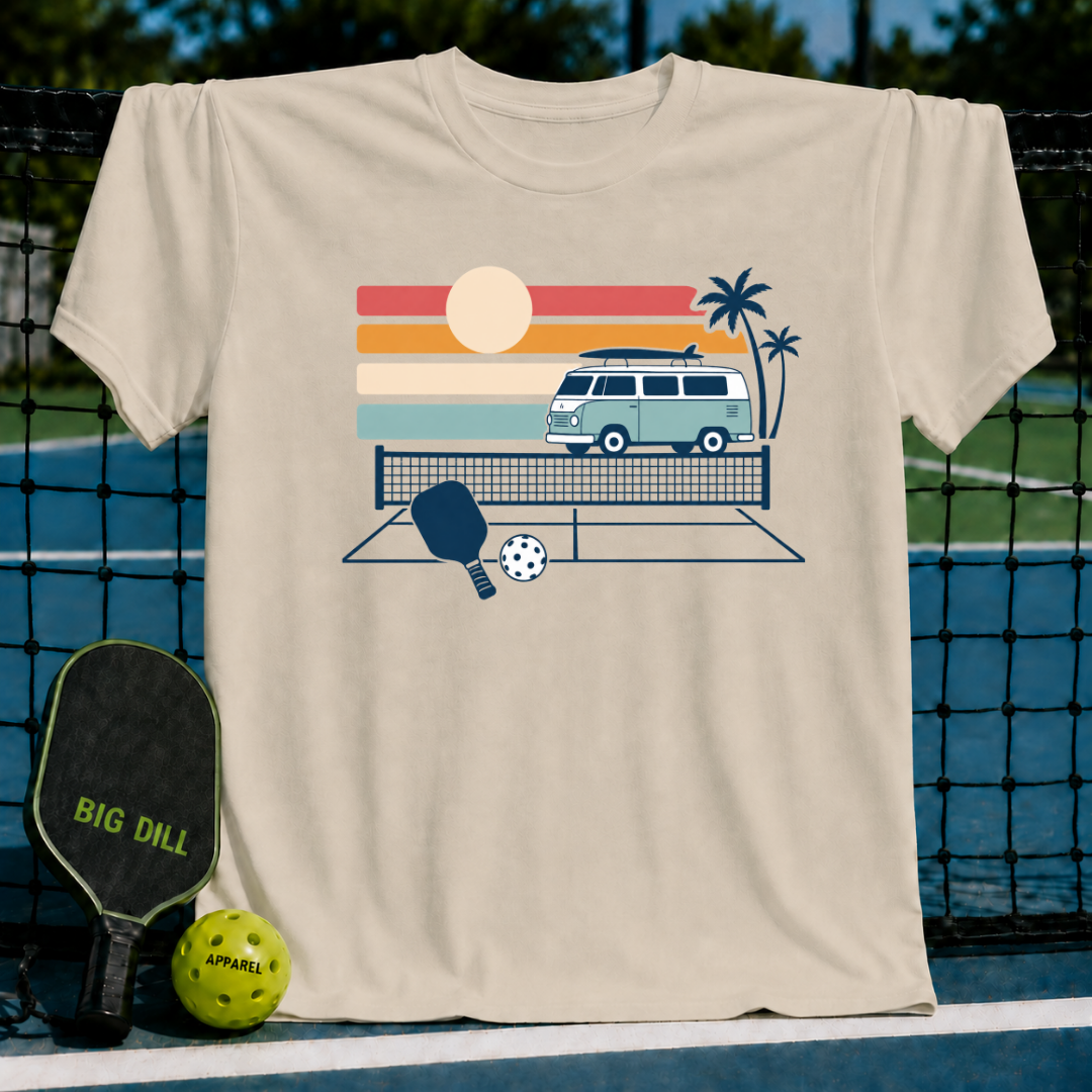 Beige crewneck t-shirt featuring a retro van, palm trees, and pickleball court graphic on a pickleball court background.