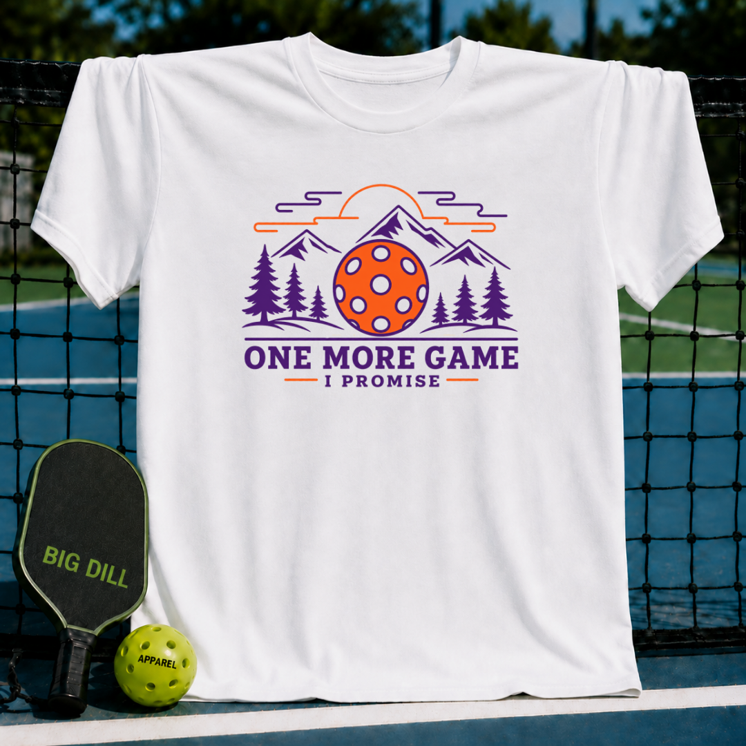White cotton t-shirt featuring a purple and orange pickleball mountain graphic with the text One More Game I Promise.