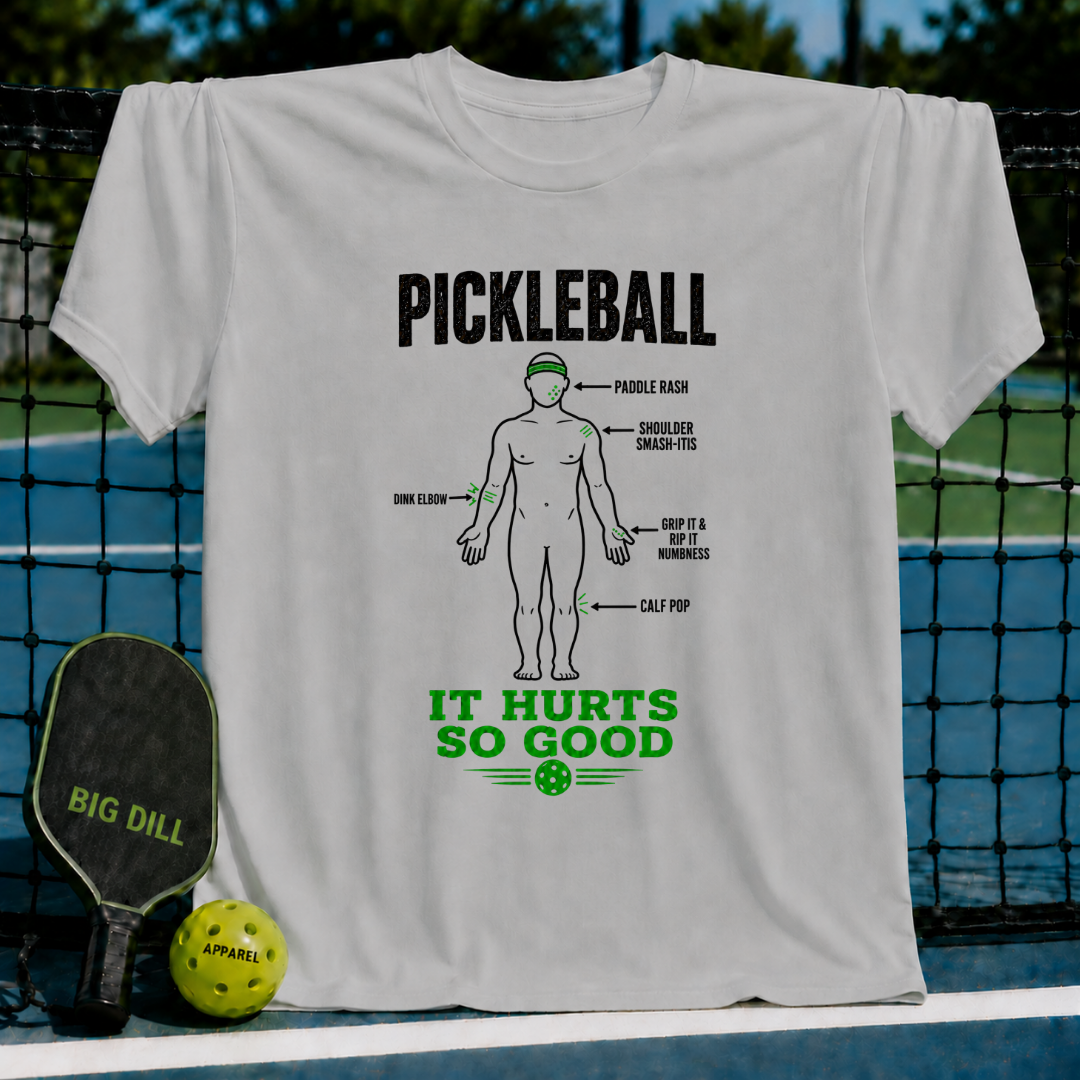 Light gray cotton t-shirt featuring a humorous pickleball injury diagram graphic in black and green text.