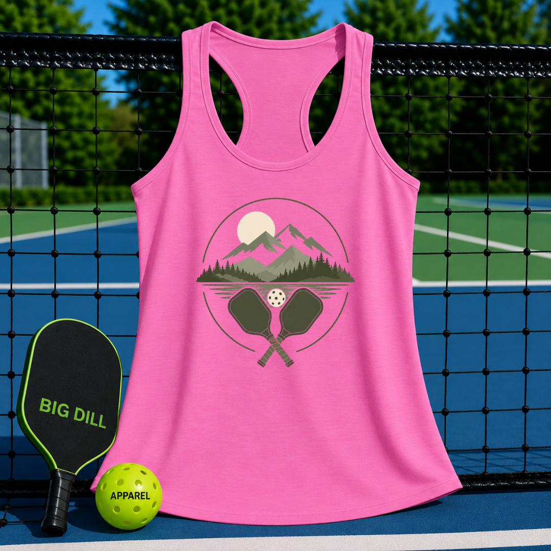 Pink racerback tank top featuring a retro mountain and pickleball graphic, displayed on a pickleball court.